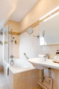 Thury-HarcourtLogis Hotel Le Relais De La Poste Restaurant Le Fil du Temps的浴室配有盥洗盆和浴缸。