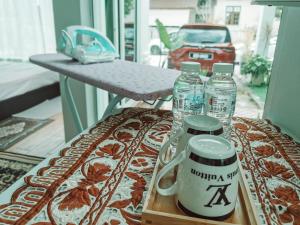 Kota BharuInap Idaman 5 With 2 Queen Bed In Kubang Kerian的阳台上的桌子和2瓶水