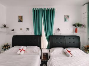 Kota BharuInap Idaman 5 With 2 Queen Bed In Kubang Kerian的绿窗帘间内的两张床