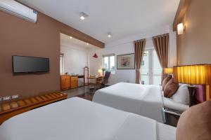 河内Hanoi Golden Sunshine Villa Hotel and Travel的酒店客房设有两张床和电视。