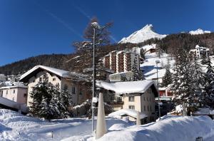 达沃斯帕森酒店的雪地中的度假胜地,背景是一座山