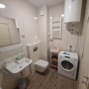 波德戈里察Stefanija的白色的浴室设有洗衣机和水槽。