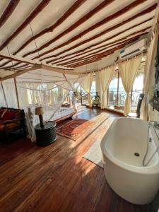 马特姆维Zi Villa Main House的一间带浴缸的浴室,位于一间铺有木地板的客房