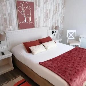 贝努维尔Hôtel Bien Être La Glycine的一间卧室配有一张带红色毯子的大床
