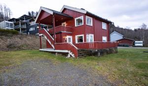 利勒哈默尔Lillehammer Camping的一座红色的房子,在院子里设有大甲板