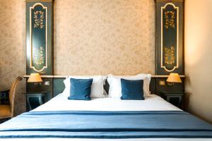巴黎布玛尔查别墅酒店的一间卧室配有一张带两个蓝色枕头的床