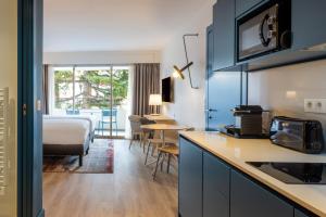 戛纳曼特浓俱乐部酒店的酒店客房带厨房、床和房间