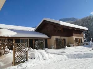 托讷Gîte Tournette的雪覆盖的房屋,有木门