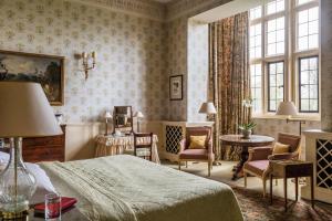 艾尔斯伯里哈特韦尔别墅&SPA的卧室配有一张床和一张桌子及椅子