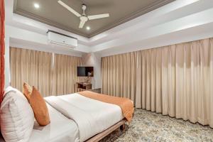 罗纳瓦拉Emerald Retreat的一间卧室配有大床和窗帘