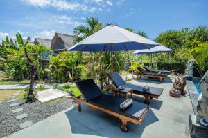 蓝梦岛Bagus Dream Beach Villa Lembongan的户外庭院配有椅子和遮阳伞。