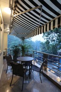 新德里R6 Luxury Peacefull & Comfortable的阳台配有桌椅和大窗户。