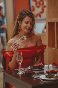 金沙Astoria Hotel All Inclusive & Private Beach的穿着红色衣服的女人在桌子上吃食物