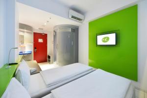 班达楠榜丹绒卡朗POP!酒店的一间医院间,设有两张床和绿色的墙壁