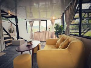 大叻Nhà Trong Sương Đà Lạt的客厅配有黄色的沙发和桌子