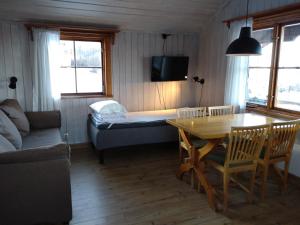 赖特维克费罗威度假山林小屋的客厅配有桌子和床。