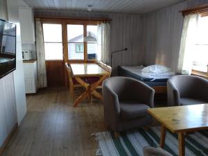 赖特维克费罗威度假山林小屋的客厅配有桌椅和1张床
