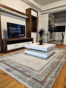 布加勒斯特Luxury Apartment的客厅配有白色桌子和电视