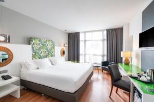 马拉加马拉加文奇酒店的配有一张床和一张书桌的酒店客房