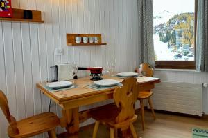 贝特默阿尔卑Charming studio, Bettmerhorn view的一张带两把椅子的木桌和一张带酒杯的桌子