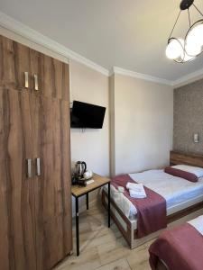 巴统MAHALI HOTEL的一间卧室配有一张床和一张书桌及电视