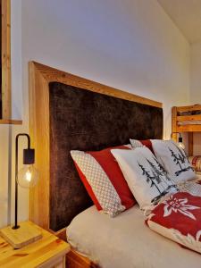 博曾安古B&B Ai Larici的一张带红色和白色枕头的木制床头板的床