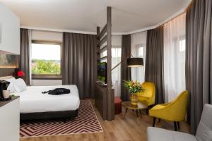 毕尔巴鄂NYX Hotel Bilbao by Leonardo Hotels的酒店客房,配有床和黄色椅子