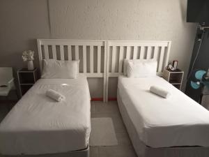 乌姆塔塔BARAKA mtata !的配有2张床的带白色床单和枕头的客房