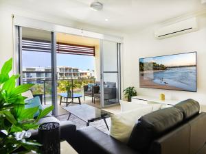 黄金海岸Emerald lakes 3 level villa的带沙发和大窗户的客厅