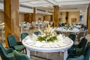 塞得港Helnan Hotel - Port Fouad的用餐室配有桌子和绿色椅子