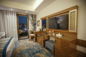 塞得港Helnan Hotel - Port Fouad的酒店客房配有一张床、一台电视和一张书桌。