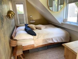 诺德克豪特"Zonnekind" Atmospheric holiday home in Noordwijkerhout near the beach的一间卧室配有带枕头的床