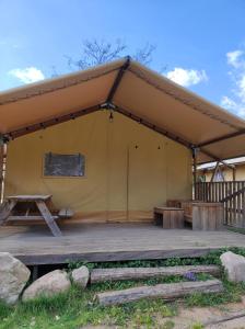 古奥巴蒂达特Càmping Parc Gualba的帐篷配有野餐桌和长凳