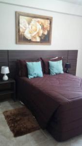 约恩维利HOTEL JOINVILLENSE的一间卧室配有一张带紫色床单和鲜花的床。