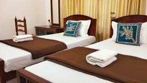 科钦KOVIL home's Guest land的酒店客房,配有三张床和毛巾