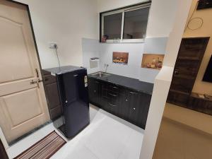 达曼Gandhi Villa的厨房配有黑色冰箱和水槽