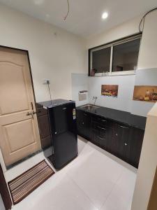 达曼Gandhi Villa的厨房配有黑色冰箱和水槽