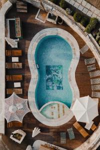 格雷梅Aza Cave Cappadocia Adult Hotel的享有带遮阳伞的游泳池的顶部景致
