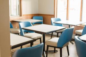 埃斯卡诺巴Travelodge by Wyndham Escanaba的配有桌椅和蓝色椅子的教室