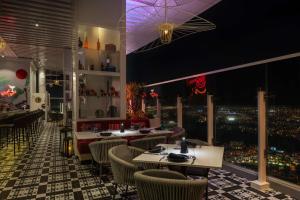 迪拜Radisson Dubai Damac Hills的一间设有桌椅的餐厅,享有城市美景