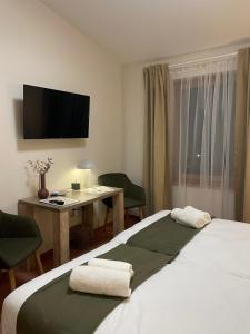 霍德梅泽瓦沙海伊肯古鲁潘齐奥酒店的酒店客房配有一张床、一张书桌和一台电视。