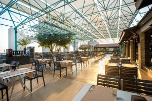 马纳夫加特Master Family Club的餐厅设有桌椅和玻璃天花板