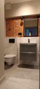 华沙特里同公园公寓的一间带水槽、卫生间和镜子的浴室