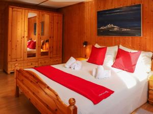 FrauenkirchApartment Haus Chumma Apt1 by Interhome的一间卧室配有一张带红色和白色枕头的大床