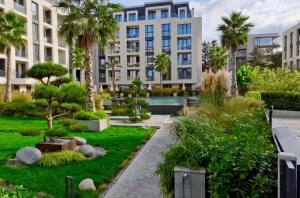 圣君士坦丁和海伦那Exclusive St Constantine Suites的公寓大楼设有花园和棕榈树。