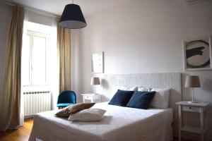 罗马泰尔米尼公寓的卧室配有白色的床和蓝色椅子
