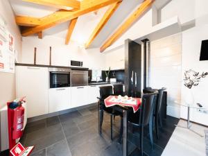 CelaHoliday Home Conceição - NZE221 by Interhome的厨房配有白色橱柜、黑色椅子和桌子