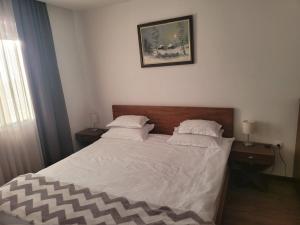 科帕奥尼克Noma Kopaonik的一间卧室配有带白色床单和枕头的床。
