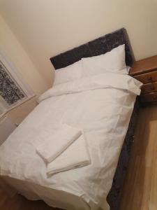 伦敦Nice Single Room near London Seven Kings Train station的一张带白色床单和枕头的床