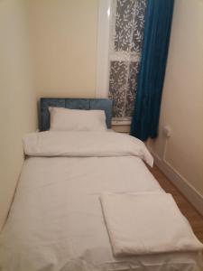 伦敦Nice Single Room near London Seven Kings Train station的小型客房 - 带2张床和窗户